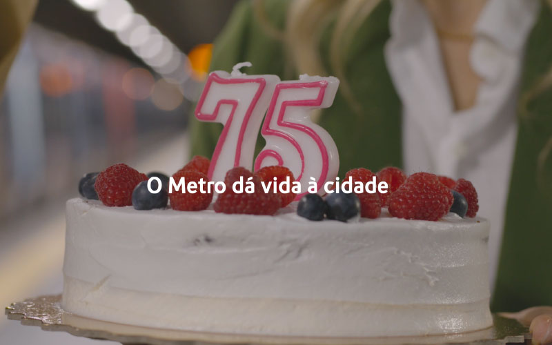 Bolo de aniversário com velas 75. Na imagem lê-se  "O Metro dá vida à ciade"