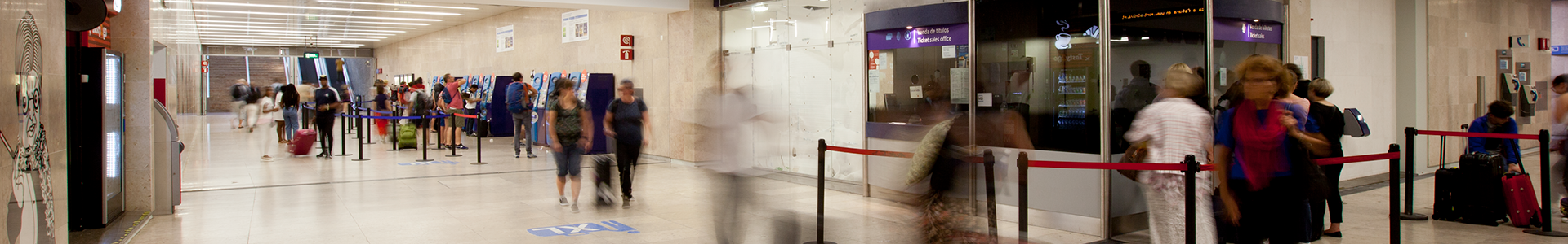 Image of Aeroporto station, with passengers buying tickets on automatic machines and at the ticket office.